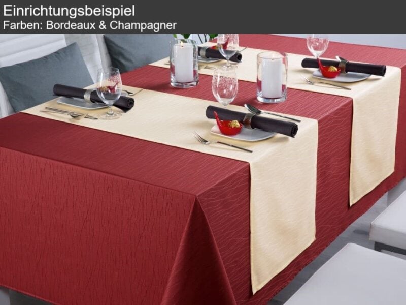 Tischdekoration mit bordeauxroten und champagnerfarbenen Tischdecken, Gläsern, Tellern und Besteck.