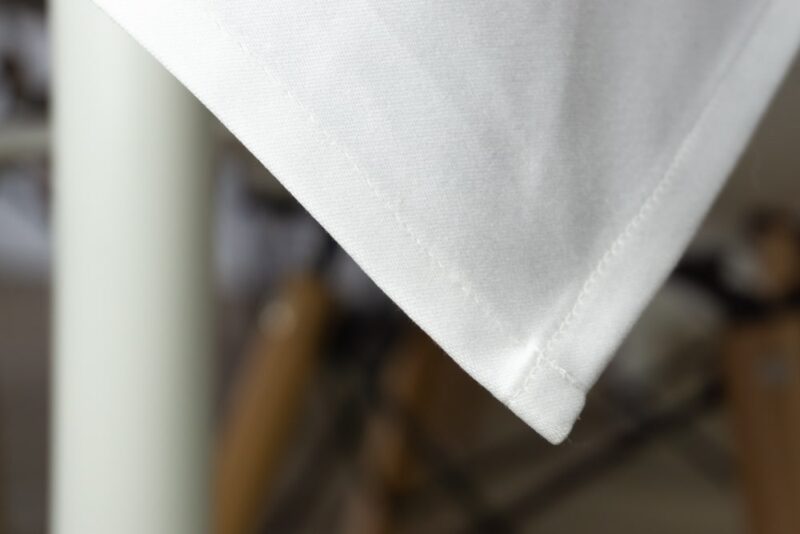Weiße Baumwolltischdecke mit feinem Saum, ideal für elegante Tischdekorationen.