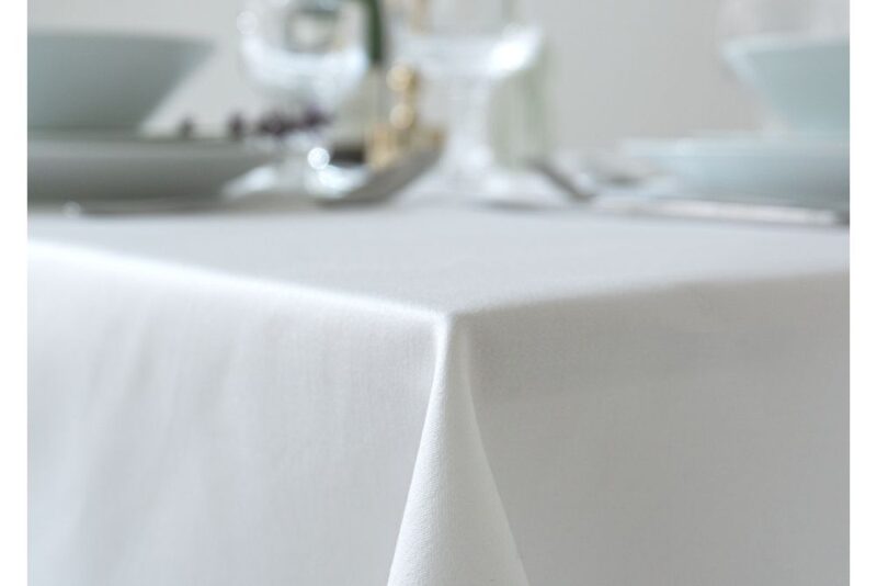 Detailaufnahme einer feinen, weißen Baumwolltischdecke mit sauberer Kante und glatter Oberfläche.