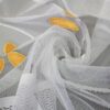 Transparente Schiebegardine mit floralen, gelben Stickereien auf weißem Netzstoff.