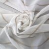 Halbtransparenter Stoff in Weiß mit braunen Linien, elegant drapiert. Ideal für Vorhänge oder Dekoration.