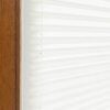 Detailaufnahme eines blickdichten, unifarbenen Plissees in Weiß, montiert im Fensterrahmen aus Holz.