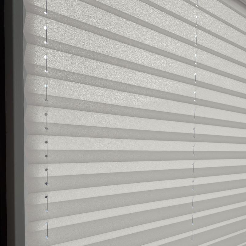 blickdichtes-plissee--basic-line--perlgrau Blickdichtes Plissee in Perlgrau mit horizontalen Falten und transparenten Schnüren. Ideal für Fensterdekoration.