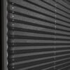 Blickdichtes Plissee in Schwarz, mit strukturierten Falten und seitlichen Zugbändern für einfache Handhabung.
