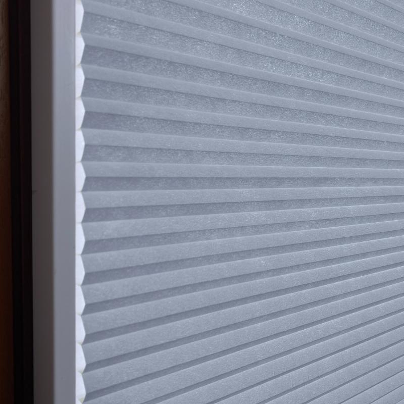 blickdichtes-wabenplissee--basic-line-kreideblau Blickdichtes Wabenplissee in Kreideblau, strukturierte Oberfläche mit horizontalen Falten, ideal für Fensterdekoration.