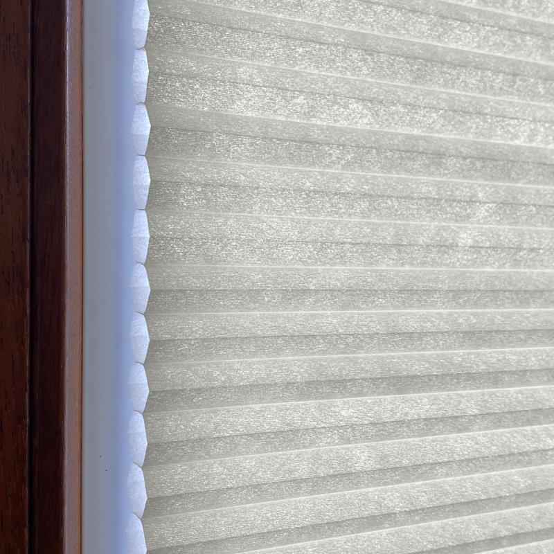 Blickdichtes Wabenplissee in Hellgrau, geeignet für Fenster, mit strukturierter Oberfläche und effizienter Wärmedämmung.