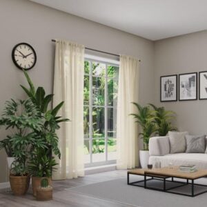 Transparente unifarbene Gardine in hellbeige mit Multifunktionsband, vor einer Fensterfront im Wohnzimmer.