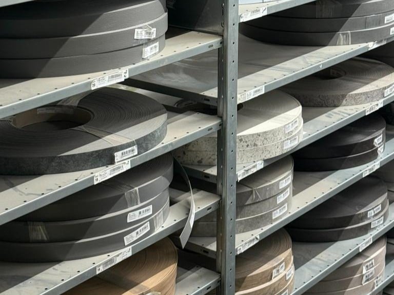 Regale mit verschiedenen Rollen aus Kunststoff in Schwarz, Grau und Braun, für individuelle Fertigung.