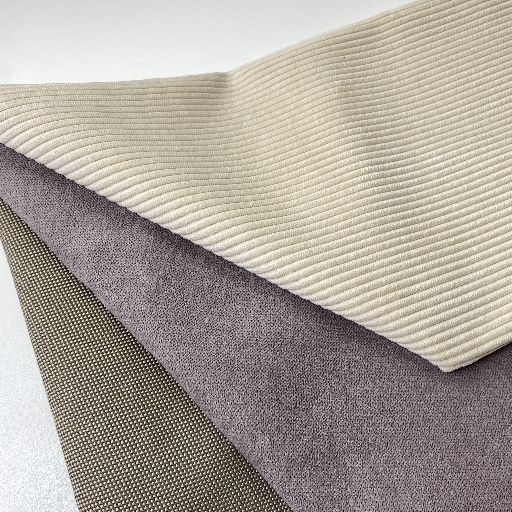 Drei Polsterstoffmuster: hellbeige Cord, grauviolett Mikrofaservelours, braungrüner Webstoff